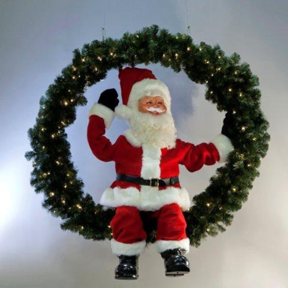 Santa Claus sitting in a fir wreath with lights.